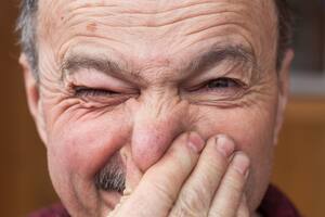 Elderly man hands nose plugs because of unpleasant smell