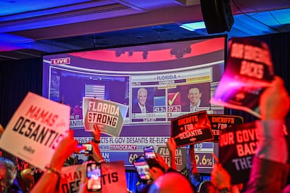 Los partidarios del candidato republicano a gobernador de Florida, Ron DeSantis, aplauden mientras ven los resultados en vivo durante una fiesta de la noche de las elecciones en el Centro de Convenciones de Tampa, Florida, el 8 de noviembre de 2022