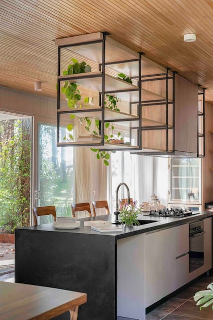 “Elegimos madera para el cielorraso, distinto del resto de la casa, para darle mayor calidez a este nuevo espacio ”. Anafe de Bosch y grifería de Hansgrohe.