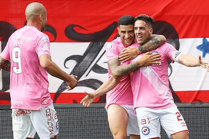 Elías Gómez abraza a Hauche, mientras Santiago Silva se suma al festejo de un gol de Argentinos