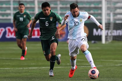 Lionel Messi empezó poco activo en La Paz y fue apareciendo con el correr de los minutos; lo persigue Diego Wayar.