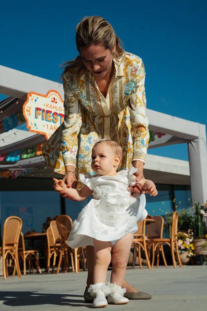 Elina, que lució un vestido Versace, ayuda a su hija a dar sus primeros pasos