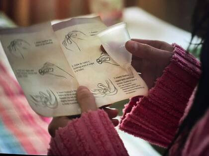 Ellie investiga las instrucciones de la copa menstrual