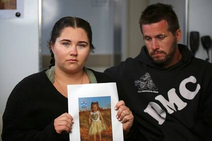 Ellie Smith, a la izquierda, y su pareja Jake Gliddon, muestran una foto de su hija desaparecida, Cleo, cerca de Carnarvon en el estado de Australia Occidental, Australia, 19 de octubre de 2021.  
(James Carmody/AAP Image/Pool vía AP)