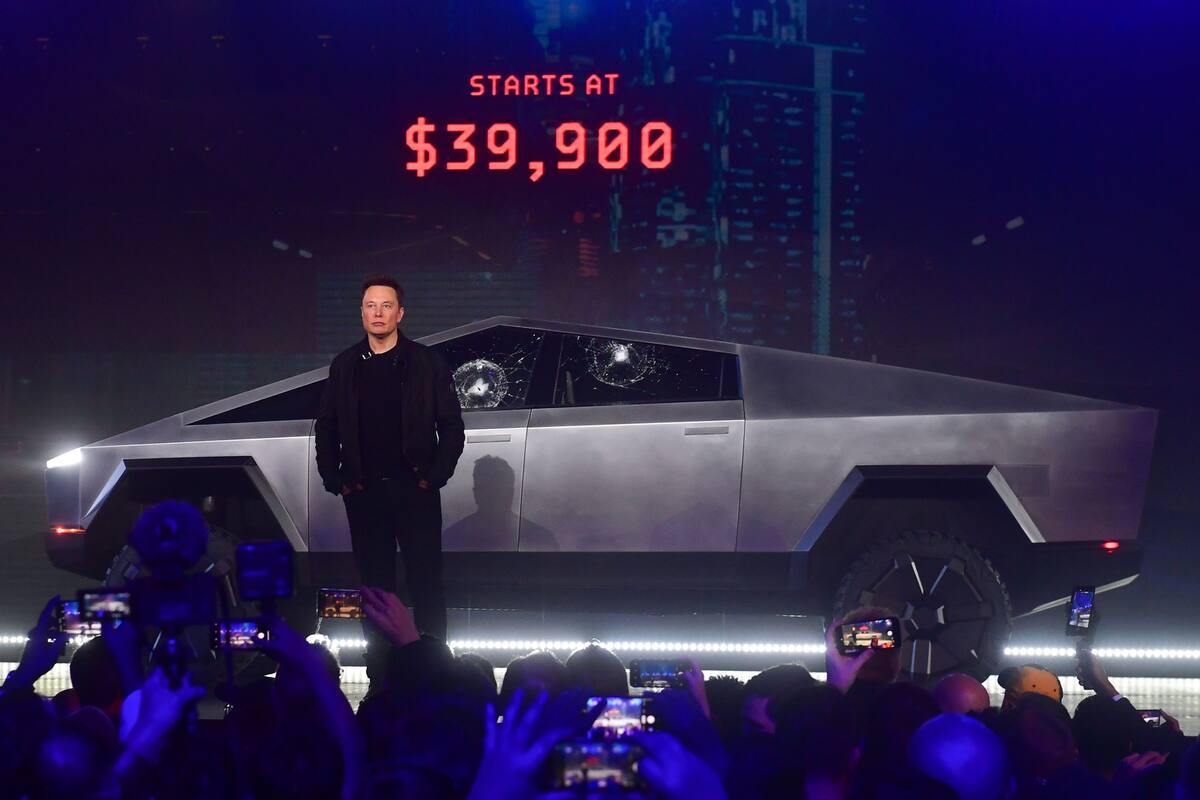 Elon Musk junto a su Tesla Cybertruck; los vidrios laterales se astillaron luego de que les pegó con una pelota de beisbol