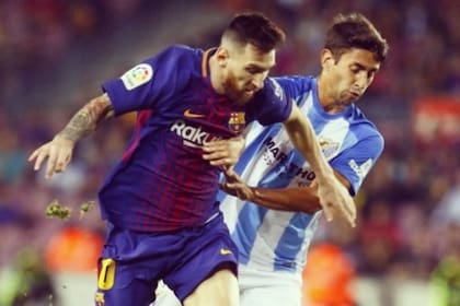 Emanuel Cecchini marca a Lionel Messi, en un Barcelona - Málaga, por la Liga de España; el mediocampista volvió a la Argentina y jugará en San Lorenzo