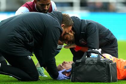 Emiliano Martinez recibe la atención de los médicos de su equipo después de golpear su cabeza contra un compañero, en el partido entre Newcastle y Aston Villa at St. James' Park