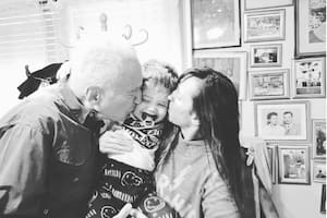 Emilio, entre los besos de su papá y su mamá