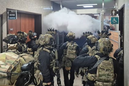 Empleados de la Asamblea Nacional rocían con un extintor a los soldados en la Asamblea Nacional en Seúl, Corea del Sur, el miércoles 4 de diciembre de 2024