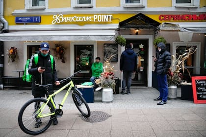 Empleados de una app de delivery en un café en Moscú. (AP Photo/Alexander Zemlianichenko)