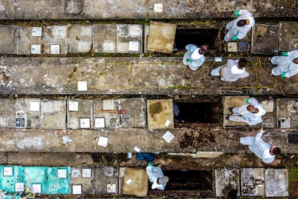 Empleados del cementerio Nova Cachoeirinha, el segundo más grande de Sao Paulo, extraen huesos de tumbas viejas para dar cabida a nuevas víctimas del Covid-19