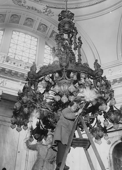 Empleados del Congreso Nacional limpian la Araña del Centenario en el Salón Azul para la apertura de sesiones de 1935.