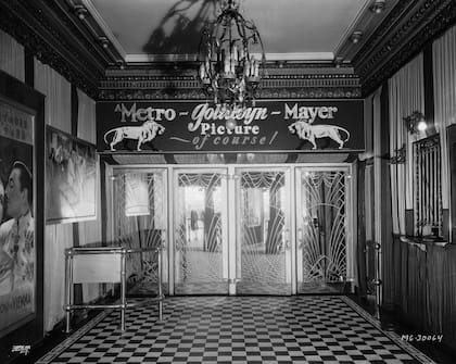 En 1933, cuando aún no se habían dividido los estudios de las exhibidoras en Hollywood, el foyer de un cine de MGM, adornado con el logotipo del león del estudio y las palabras "¡Una película de Metro-Goldwyn-Mayer, por supuesto!" (Foto a través de la Fundación John Kobal / Getty Images)
