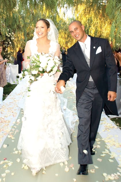 En 2001, Jennifer López se casó con el bailarín Chris Judd y lució un romántico diseño con profundo escote, falda acampanada y mangas transparentes de tul bordado