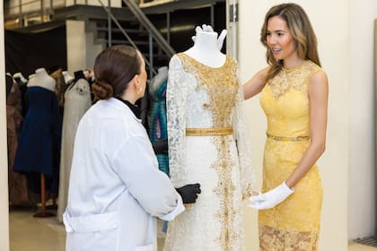 "En 2013, en París, antes de salir a la pasarela, Jorge me tomó de las manos y me dijo ‘Vas encontrar a un hombre maravilloso y te vas a casar… ¡con este vestido!’", recuerda Elina. En la foto, junto a María Lizaso, de Gestión de Colecciones del Museo del Traje.