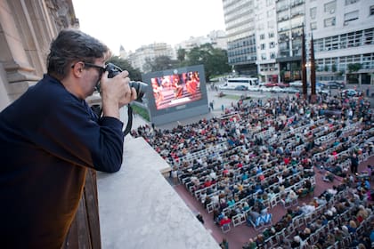 En acción, desde una ventana del Teatro Colón, Parpagnoli fotografía al público de un espectáculo al aire libre en la Plaza Vaticano