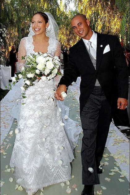 En busca de un diseño romántico, Jennifer Lopez eligió a Valentino para su boda con el bailarín Cris Judd en 2001. El diseñador creó im vestido de color marfil con encaje Chantilly y mangas transparentes