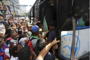 En Caracas,uno de los estados afectados, la gente se amontona en una parada de colectivo, luego de que se suspendiera el subte