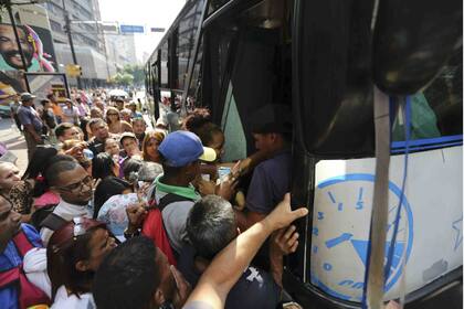 En Caracas,uno de los estados afectados, la gente se amontona en una parada de colectivo, luego de que se suspendiera el subte