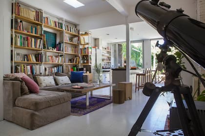 En casa de los dueños de Bruto Estudio, sobre el sofá en forma de L heredado, almohadones de Compañía de Blockprint. Biblioteca (diseño Estudio YME) en caño pintado blanco y guatambú macizo.