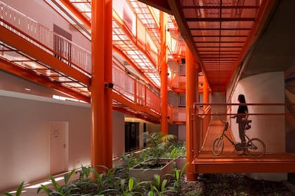 En Casa HO, edificio de viviendas en el eje Donado-Holmberg del Grupo Uno en Uno, la sorpresa al ingresar es una rampa naranja para bicicletas que ocupa el patio central y permite llegar hasta cada unidad pedaleando desde la calle.
