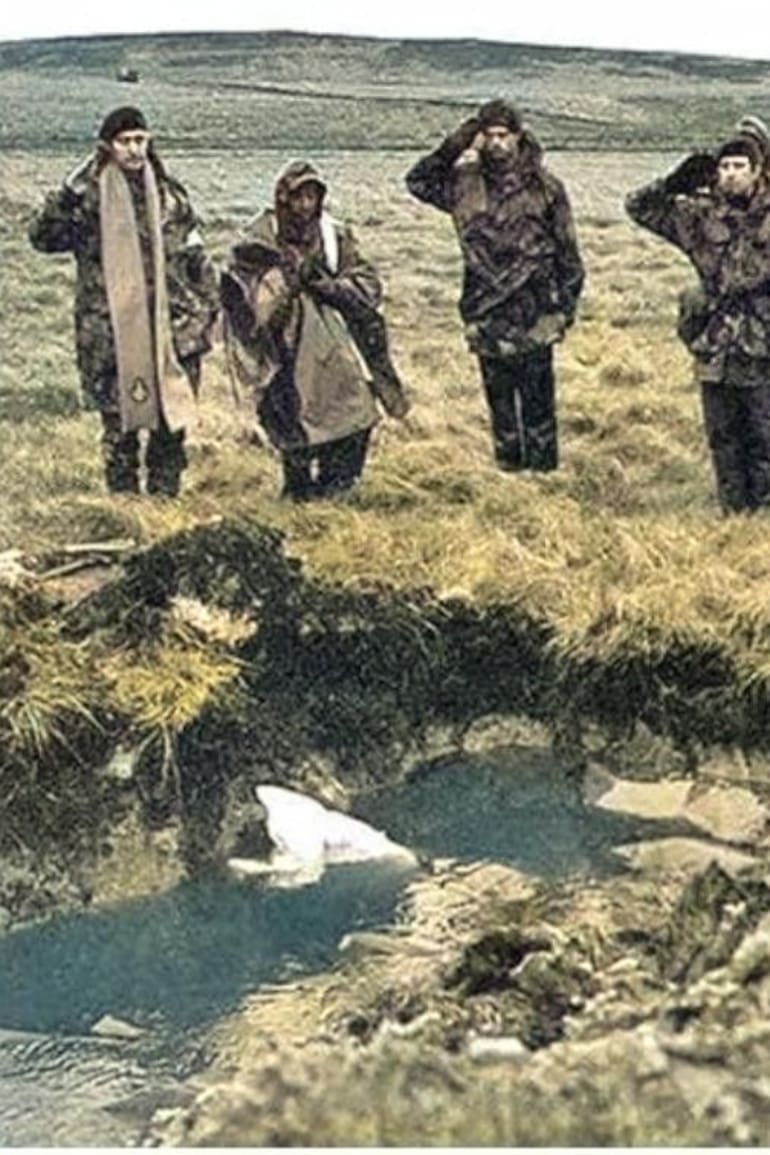 En Darwin, el padre Mora (el segundo, de izquierda a derecha) junto al religioso británico y soldados, bendiciendo los cuerpos de los caídos durante el enfrentamiento