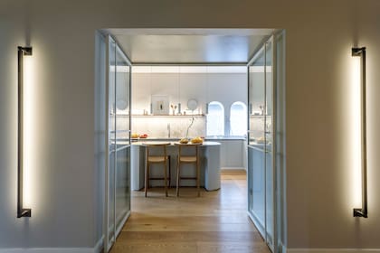 En el acceso a la cocina, apliques lineales de pared (Huup).