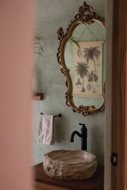 En el baño conviven objetos vintage con elementos de madera y piedra.