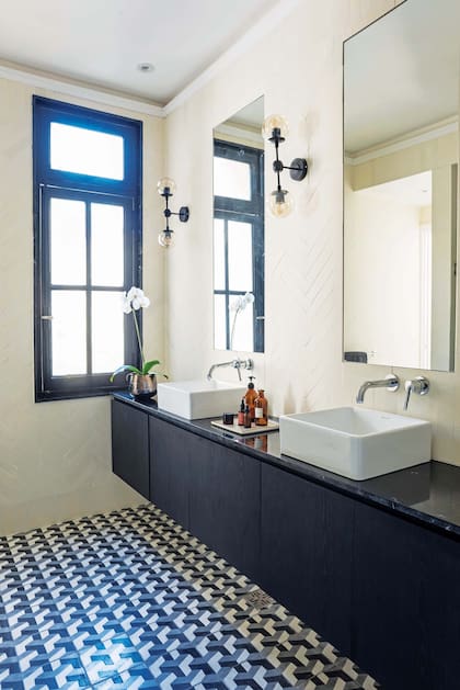 En el baño en suite, calcáreos geométricos para el piso (Compañía Argentina de Pisos) y para las paredes, en tono crudo y formato espina de pez (Noi Estudio).