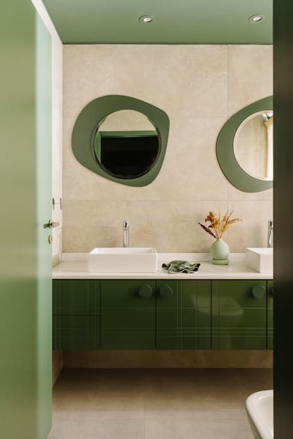 En el baño en suite, proyecto de la Arq. Camila Monge, techo verde mate, vanitory en laca brillante y tiradores circulares, como los espejos