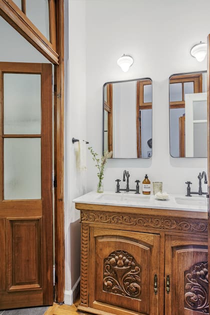 En el baño, mueble antiguo con mesada y grifería con pico móvil ‘Satis’ (Agata Faucets); espejos ‘Tern’ (Manjatan).