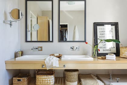 En el baño, vanitory de guatambú blanqueado, bien neto y liviano, con un estante inferior (para colocar canastos), grifería monocomando ‘Libby’ (FV) de pared y bachas Cree (Barugel Azulay).