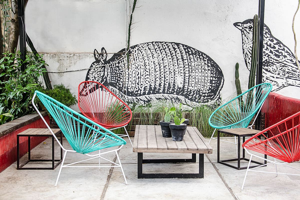 En el barrio porteño de Coghlan, una casa antigua inspira la decoración de una terraza con potencial, con un mural realizado por Teófilo Riadigos que se completa con muebles simples y coloridos