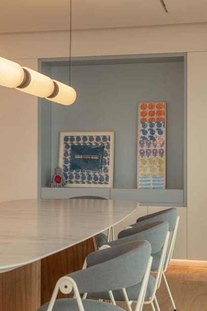 En el comedor de este departamento diseñado por Arq & Co un nicho en la pared dialoga con el juego de sillas (La Feliz). Obras de arte de Milagros Pini.