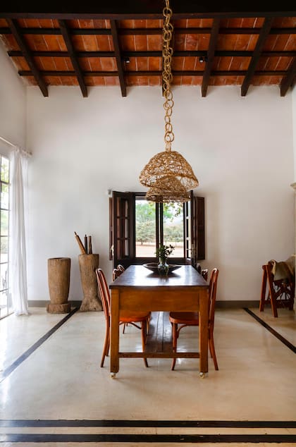 En el comedor de Finca Valentina, una gran mesa de madera rodeada con sillas Thonet, todas del Mercado de Pulgas de Dorrego.