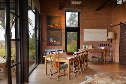 En el comedor, un juego que trajeron de la chacra de Punta del Este; a las sillas, que eran de la madre de Diego, las aclararon y las retapizaron. En la pared y del lado izquierdo, dos obras del artista Carlos Reales; del lado izquierdo,
un collage de Mónica Fierro