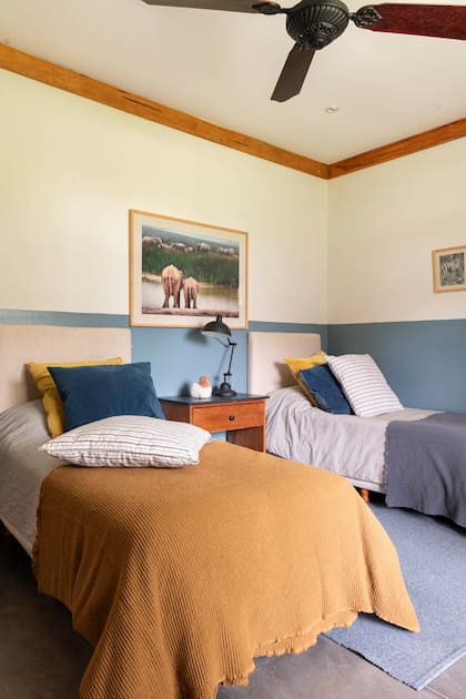 En el cuarto de Santos, cama con respaldo de lino y ropa de cama en composé (todo L’Epicerie). Zócalo pintado y fotos de animales.
