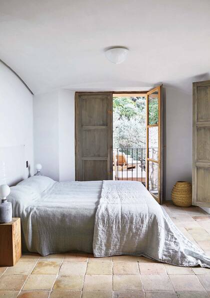 En el dormitorio, la aparición del lino en la ropa de cama anula cualquier sensación de dureza o despojo. La terracota del piso y la madera rústica de las aberturas dan su toque cálido a la paleta neutra.