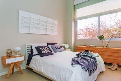En el dormitorio, mesas de luz ‘Trípode’, respaldo hecho a medida y cómoda de doce cajones de paraíso con lustre natural (todo de BLVD).