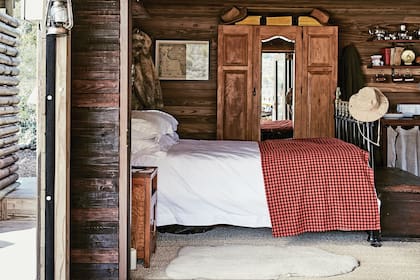 En el dormitorio, revestimiento de madera y cama antigua de hierro.