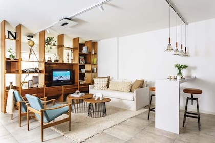 En el estar, sofá con funda en tussor off white y almohadones (Paul French Gallery). Mesas ratonas de petiribí y hierro (Alejandra Nusenovich). Sillones estilo escandinavo (Broca). Alfombra de lana cruda (Graciela Churba).
