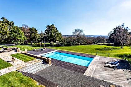 En el exterior, la propiedad cuenta con pileta, canchas de tenis y amplios jardines