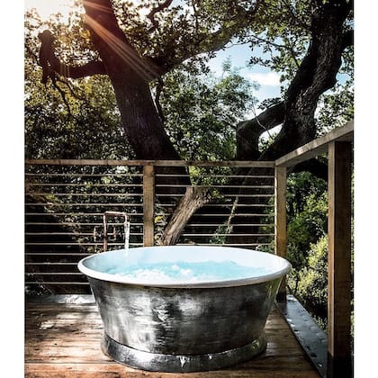 En el exterior, una bañera con hidromasajes está lista para usar y disfrutar la naturaleza
