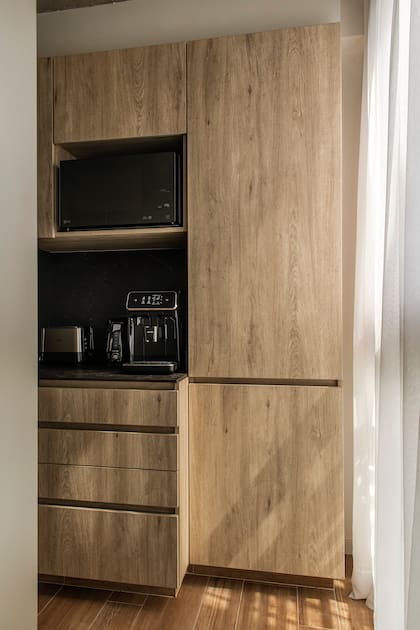 En el extremo de esta cocina lineal junto a la ventana, microondas y coffee station. Nuevamente, los artefactos en negro. Cortinas (La Deco Privé).