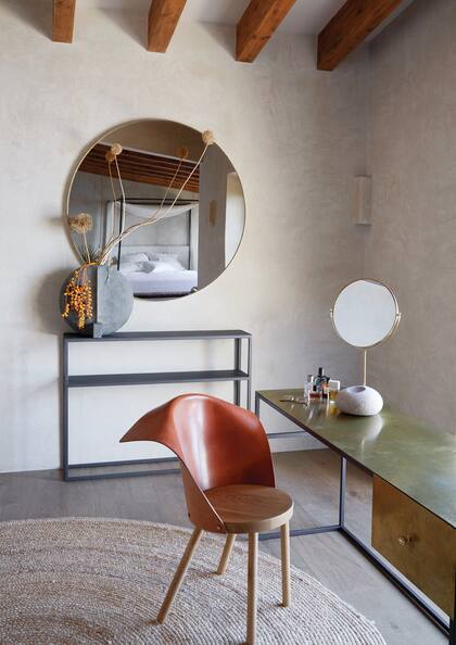 En el extremo del cuarto principal (la cama se refleja en el espejo circular), una mesa le da al maquillaje o a un escritorio