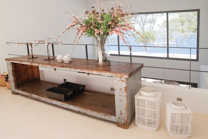 En el hall de arriba, una mesa antigua vuelve a combinar el color de la madera con un azul claro decapado.