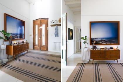En el hall de entrada, una foto de José: “Resplandor del Este”. La cómoda vintage sostiene un guacamayo de piedras comprado en Río de Janeiro, una estatua del Morro Dois Irmãos y un bloque de sal traído de Salinas Grandes, Jujuy. Alfombra (Casa Sixta).
