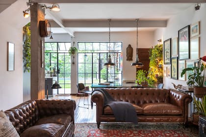 En el interior se eliminaron divisiones para integrar living, comedor y cocina, reforzando con columnas; sobre una de ellas, el antiguo reloj del Ferrocarril General Mitre, como un guiño al origen de la casa