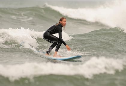 En el invierno de 2020, después
de recibir una tabla y un traje de
neoprene de regalo de parte de
su marido, Carola se animó al surf
y comenzó a tomar clases en la
misma escuelita a la que asisten
sus hijos.