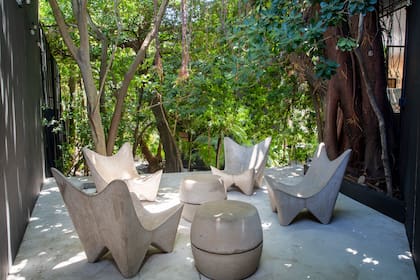 En el jardín, en uno de los rincones de la casa. armó un espacio para encuentros con amigos.